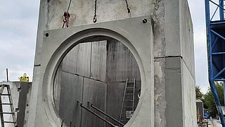 Platzieren eines Betonschachts mittels Kran in Anras