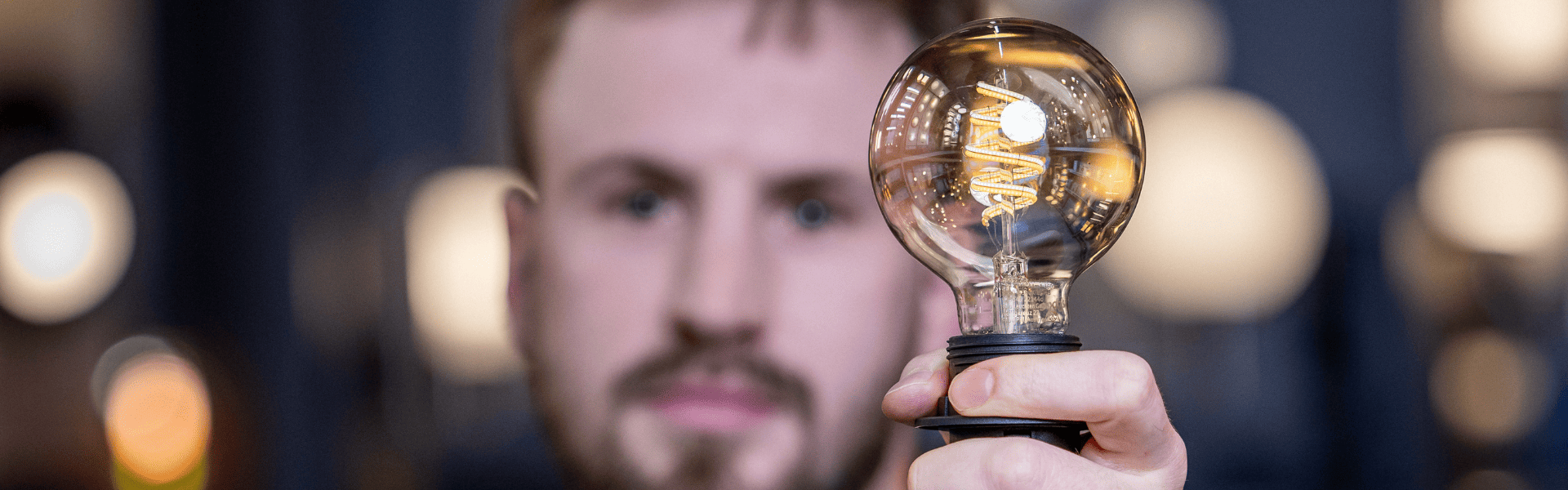 Mann hält leuchtende Lampe in linker Hand