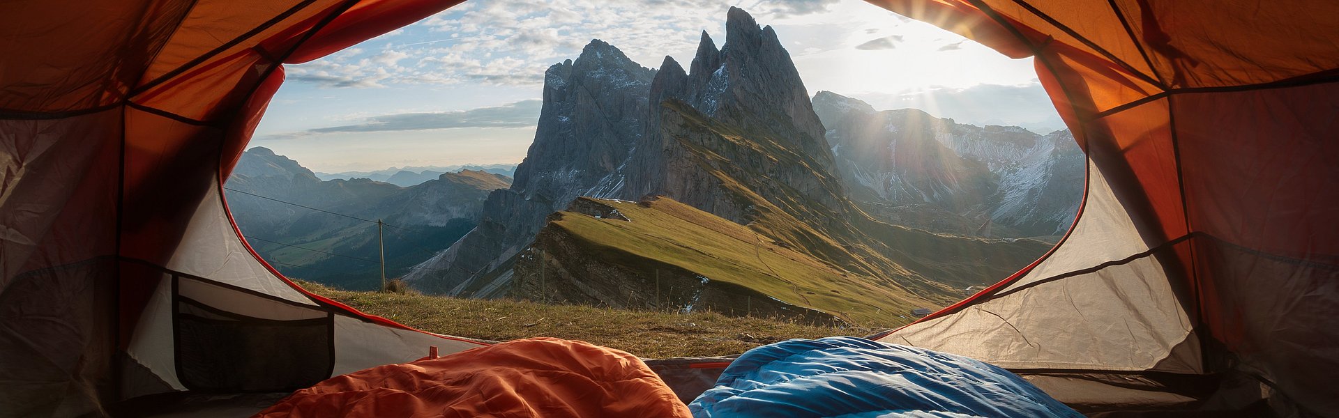 Aussicht aus einem geöffneten Zelt auf Berge