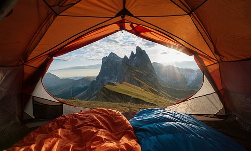 Aussicht aus einem geöffneten Zelt auf Berge