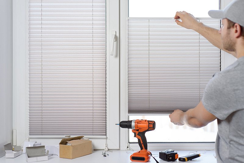 Handwerker bei der Montage eines Fenster Sonnenschutzes