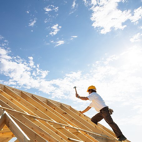 Arbeiter bei der Konstruktion eines Dachgrundgerüstes mit Holz