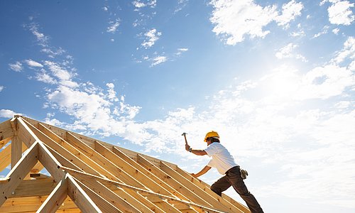Arbeiter bei der Konstruktion eines Dachgrundgerüstes mit Holz
