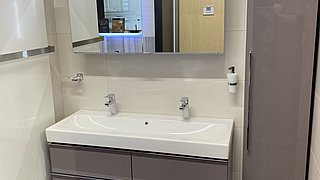 Badezimmer-Beispiel mit grauen Hochglanzmöbeln im Würth-Hochenburger Baumarkt Hallein