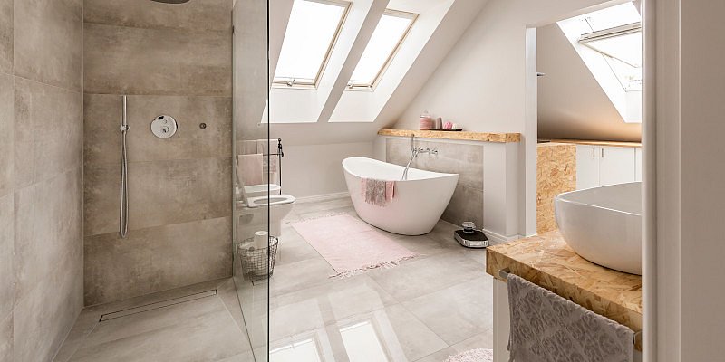 Schlichtes, modernes Badezimmer mit Badewanne und Dachfenster