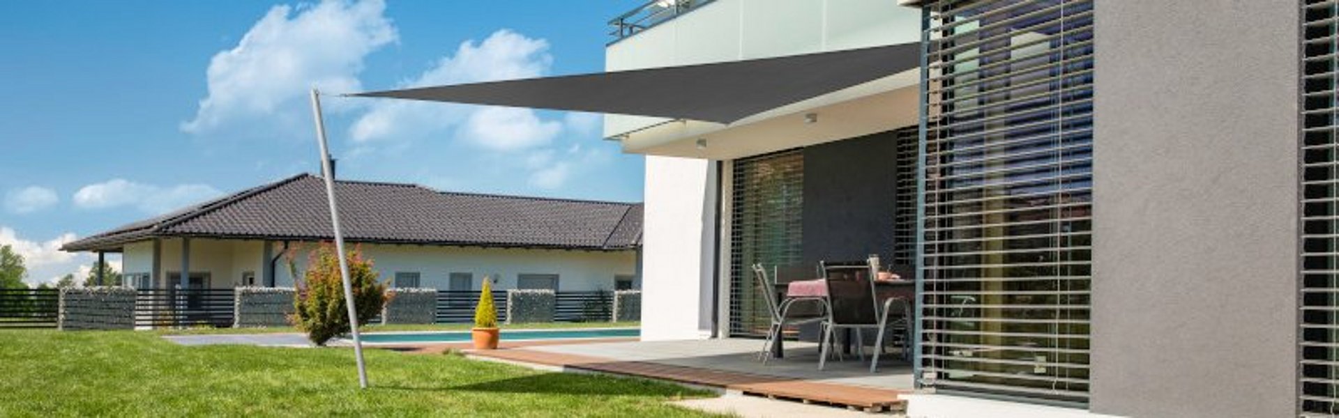 Graues Dreieck-Sonnensegel von Windhager als moderne Terrassenbeschattung