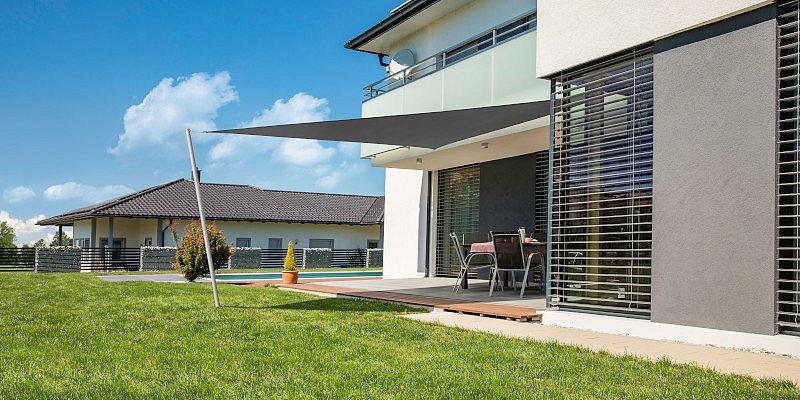 Graues Dreieck-Sonnensegel von Windhager als moderne Terrassenbeschattung