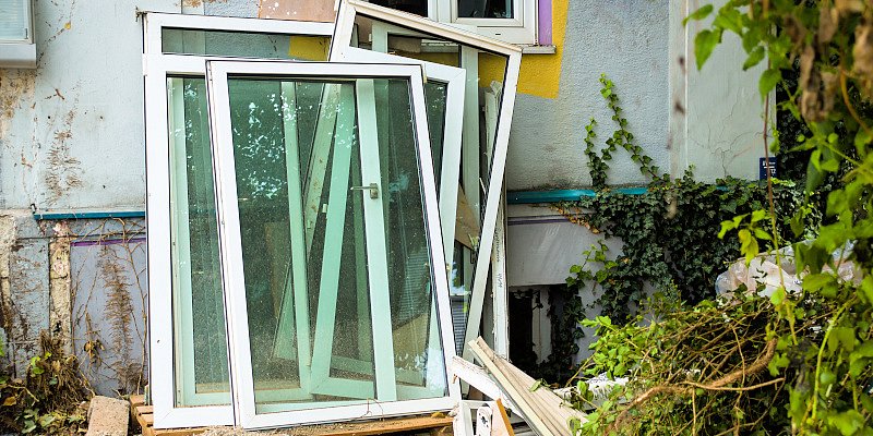 Alte Flügelfenster stehen nach der Demontage auf einer Palette