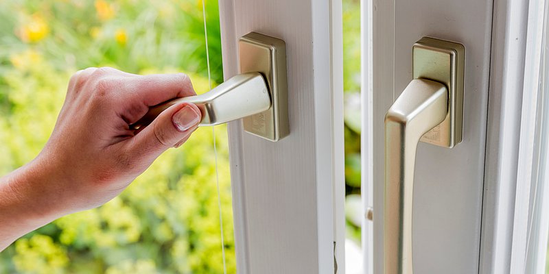  Frau beim Öffnen eines Fensters 