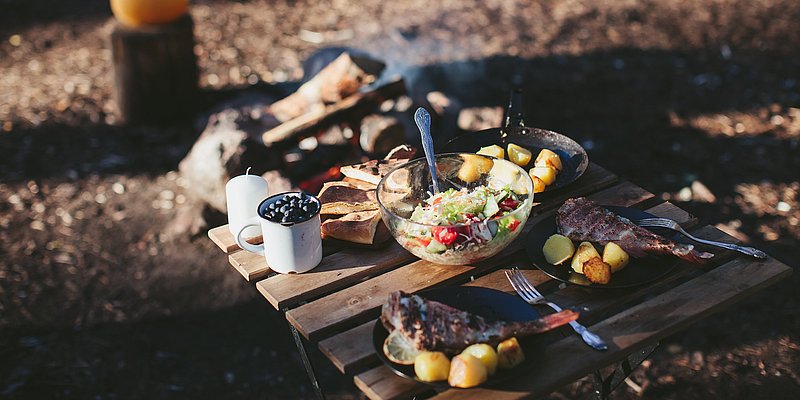 Gekochtes Essen am Campingplatz auf einem Klapptisch