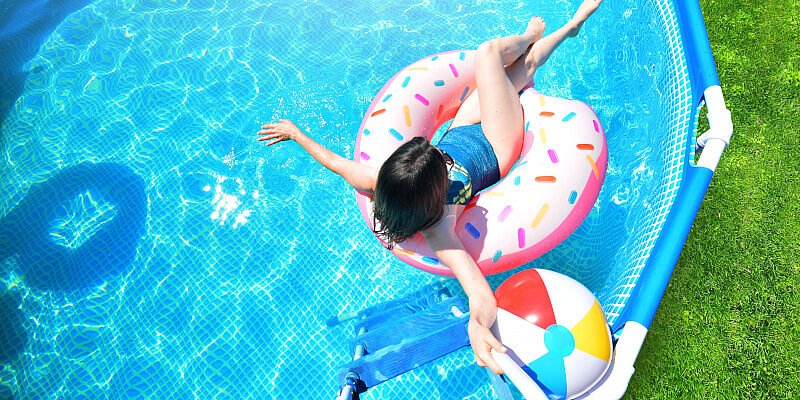 Frau genießt bei schönem Wetter das kühle Nass des Pools