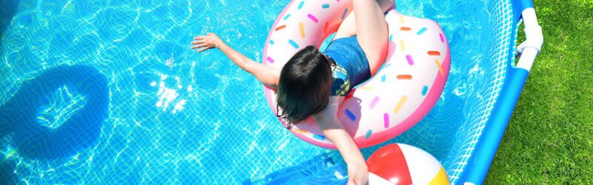 Frau genießt bei schönem Wetter das kühle Nass des Pools