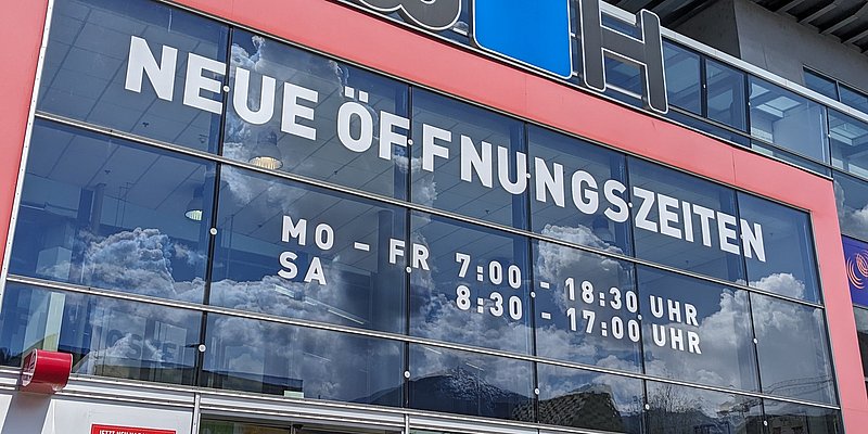 Fassade vom Baumarkt Innsbruck mit Fassadenbeklebung zu neuen Öffnungszeiten