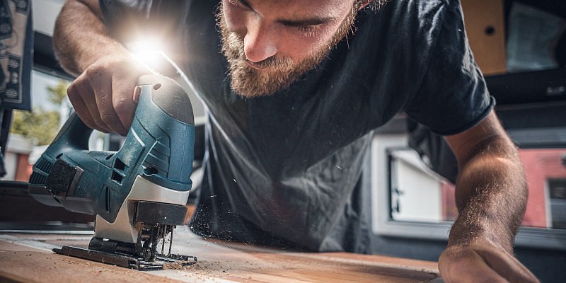 Handwerker arbeitet mit Stichsäge an Holz