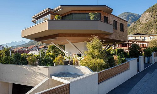 Wohnhaus im Baumhausstil mit Garten und Bergen